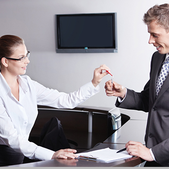 Woman hands a man a key, representing new office space at Austria Business Center, Dubai.